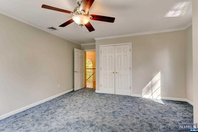 unfurnished bedroom with a closet, ceiling fan, crown molding, and carpet