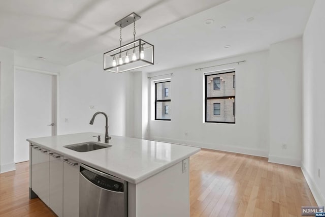 kitchen with sink, stainless steel dishwasher, decorative light fixtures, a kitchen island with sink, and white cabinets