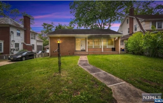 view of front of home featuring covered porch and a yard