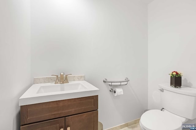 bathroom featuring tile patterned flooring, vanity, and toilet