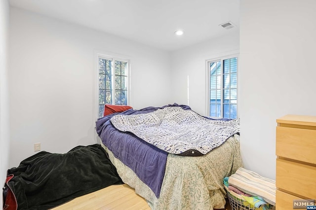 bedroom with multiple windows and wood-type flooring