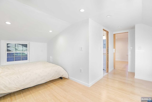 bedroom featuring vaulted ceiling and light hardwood / wood-style flooring