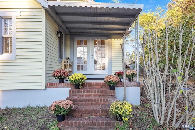 doorway to property featuring covered porch and french doors