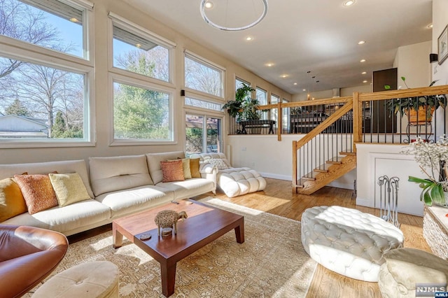 living room with a towering ceiling and light hardwood / wood-style floors