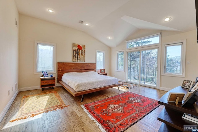 bedroom featuring access to exterior, light wood-type flooring, and multiple windows