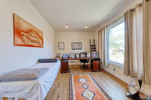 bedroom featuring multiple windows and light hardwood / wood-style flooring