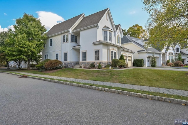 victorian home featuring a garage and a front yard