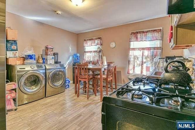 clothes washing area featuring washing machine and dryer and light wood-type flooring