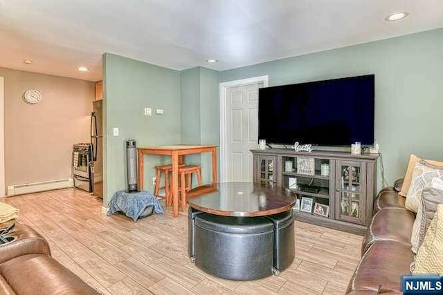 living room with baseboard heating and light wood-type flooring