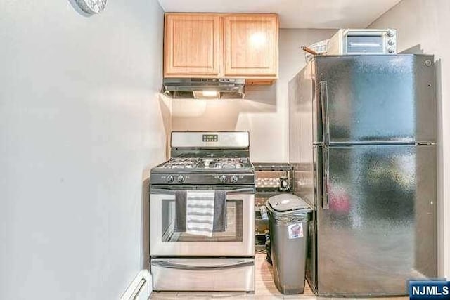 kitchen with black refrigerator, light brown cabinetry, and stainless steel gas stove