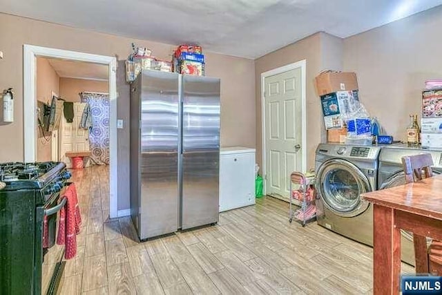 laundry area featuring light hardwood / wood-style floors and washer / dryer