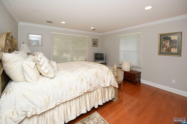 bedroom with hardwood / wood-style floors and crown molding