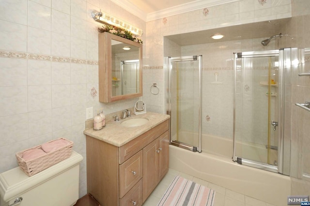 full bathroom with tile patterned floors, bath / shower combo with glass door, toilet, tile walls, and ornamental molding