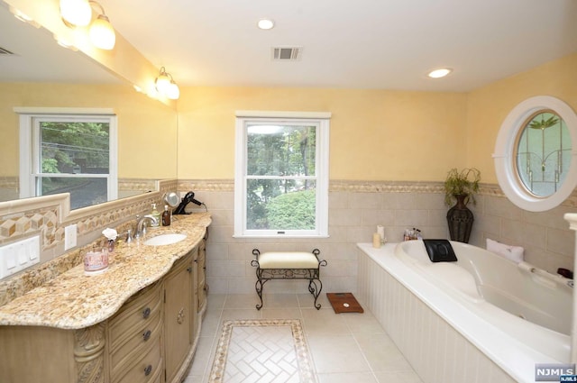 bathroom featuring tile patterned flooring, plenty of natural light, tile walls, and vanity