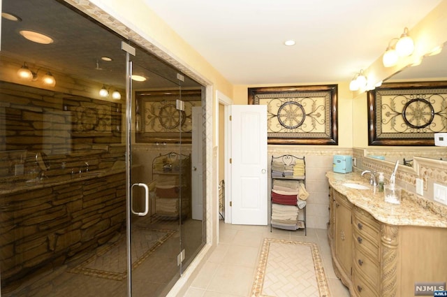 bathroom featuring tile patterned flooring, vanity, and walk in shower