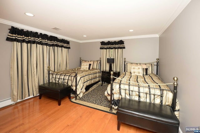 bedroom featuring hardwood / wood-style floors and crown molding