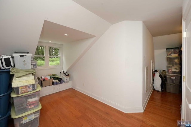 additional living space with hardwood / wood-style flooring