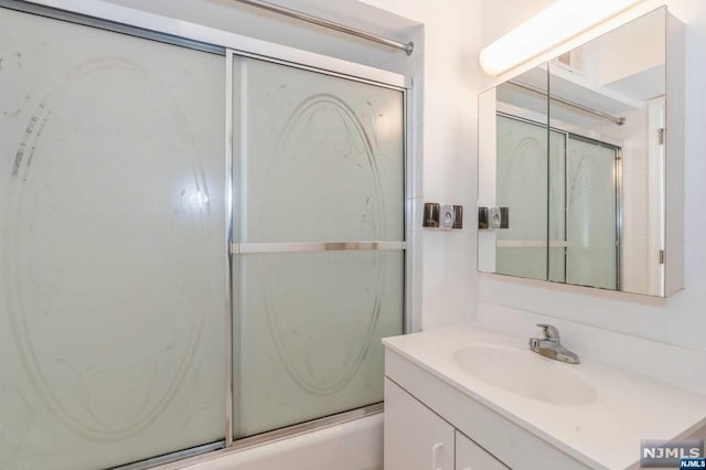 bathroom featuring shower / bath combination with glass door and vanity