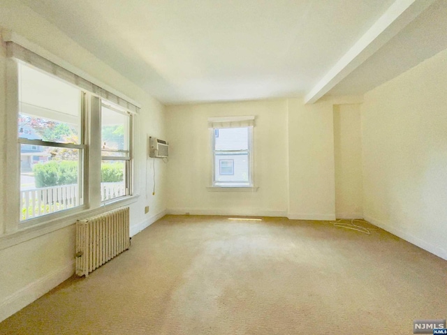 empty room with radiator, light carpet, and a wall mounted air conditioner