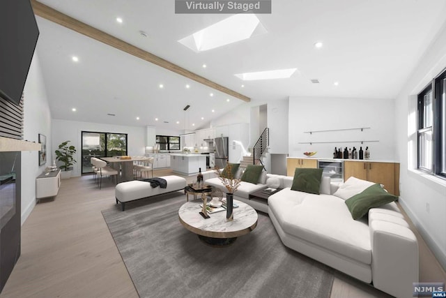 living room with high vaulted ceiling, wine cooler, a skylight, light wood-type flooring, and beam ceiling