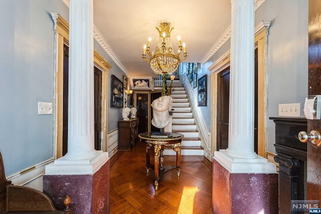 hallway with dark parquet floors, an inviting chandelier, crown molding, and decorative columns