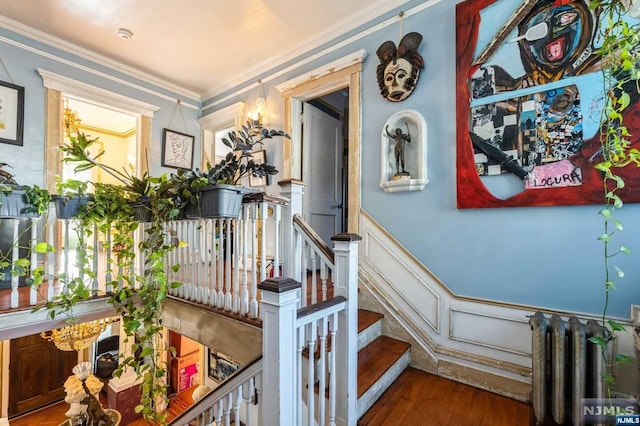 staircase with hardwood / wood-style flooring and ornamental molding