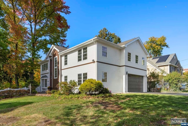 view of side of home with a garage and a lawn