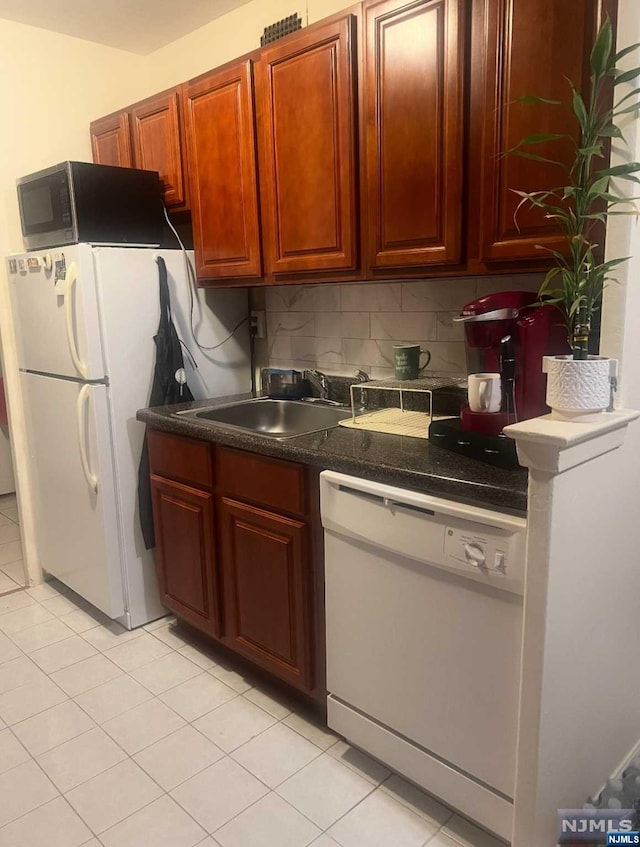 kitchen with light tile patterned flooring, sink, white appliances, and backsplash