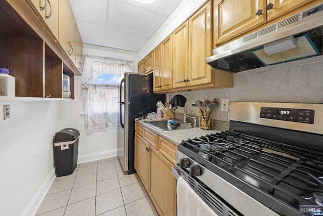 kitchen featuring sink, light brown cabinets, decorative backsplash, light tile patterned floors, and appliances with stainless steel finishes