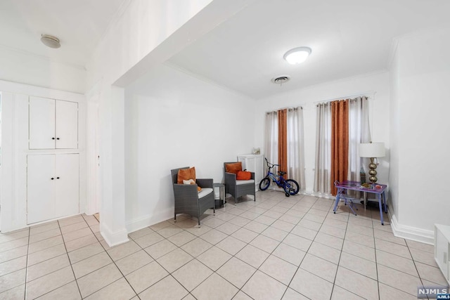 living area featuring light tile patterned floors and ornamental molding