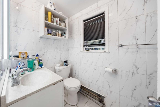 bathroom featuring vanity, toilet, and tile walls