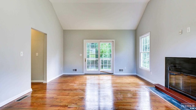 unfurnished living room featuring hardwood / wood-style floors and high vaulted ceiling