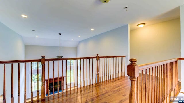 hall featuring lofted ceiling and hardwood / wood-style flooring