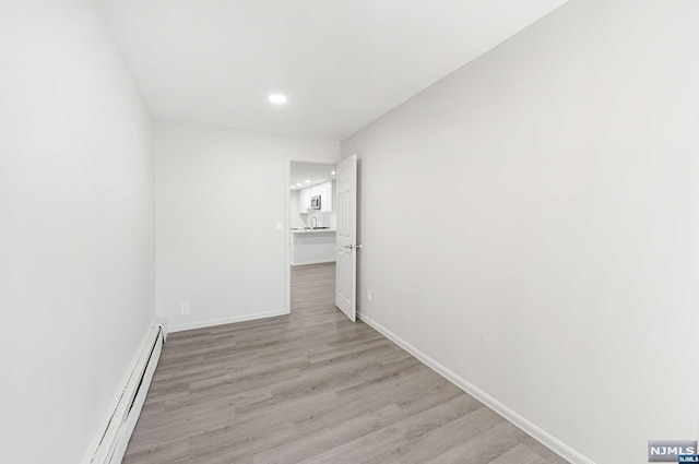 hall featuring light hardwood / wood-style floors and a baseboard radiator