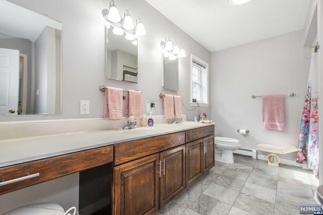 bathroom with toilet, vanity, and a baseboard heating unit