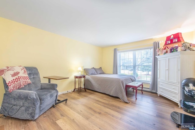 bedroom with hardwood / wood-style floors and a baseboard radiator