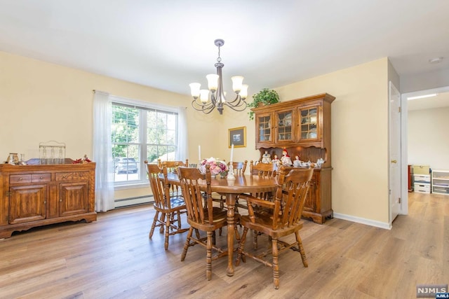 dining area with light wood-type flooring, a baseboard heating unit, and a notable chandelier