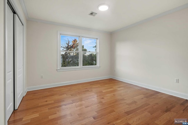 unfurnished bedroom featuring light wood-type flooring and ornamental molding