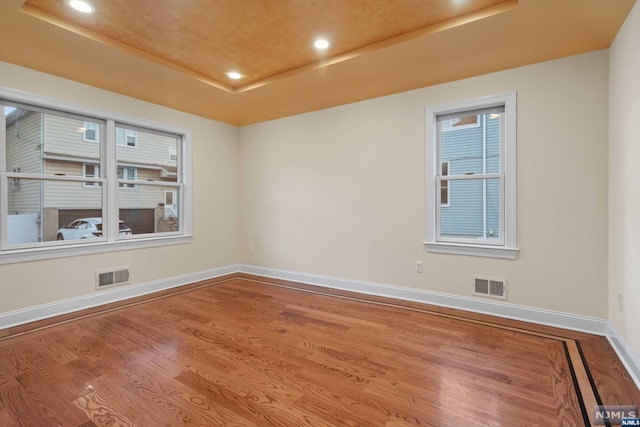 unfurnished room featuring hardwood / wood-style floors and a raised ceiling