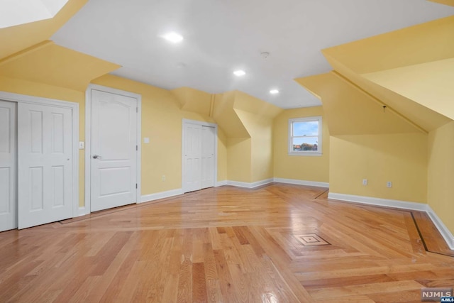 additional living space with vaulted ceiling and hardwood / wood-style flooring