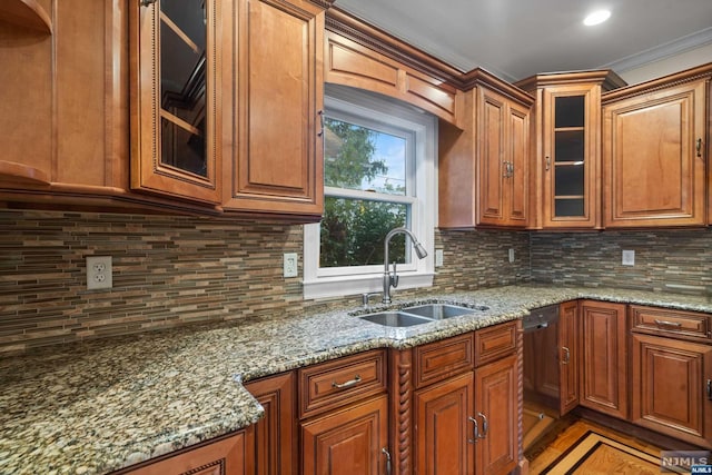 kitchen with dishwashing machine, light stone countertops, and sink