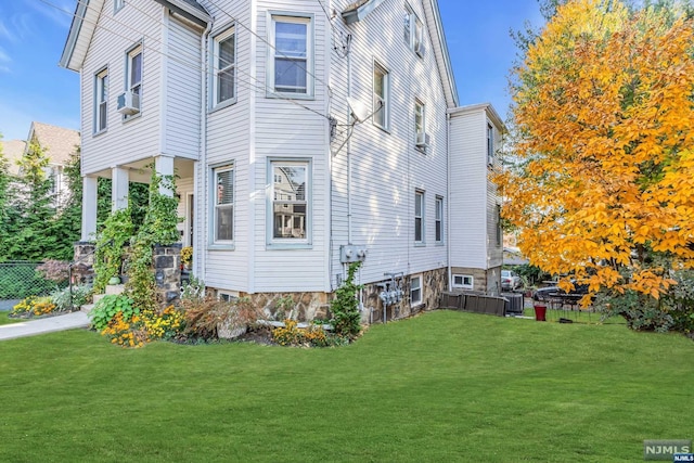 view of property exterior with a yard and central AC unit