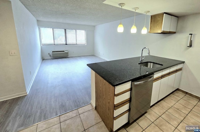 kitchen featuring sink, light hardwood / wood-style flooring, stainless steel dishwasher, decorative light fixtures, and white cabinets