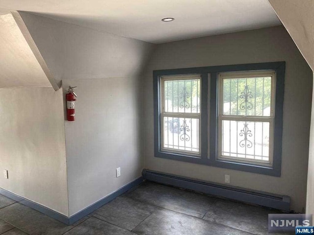 additional living space with lofted ceiling and a baseboard heating unit