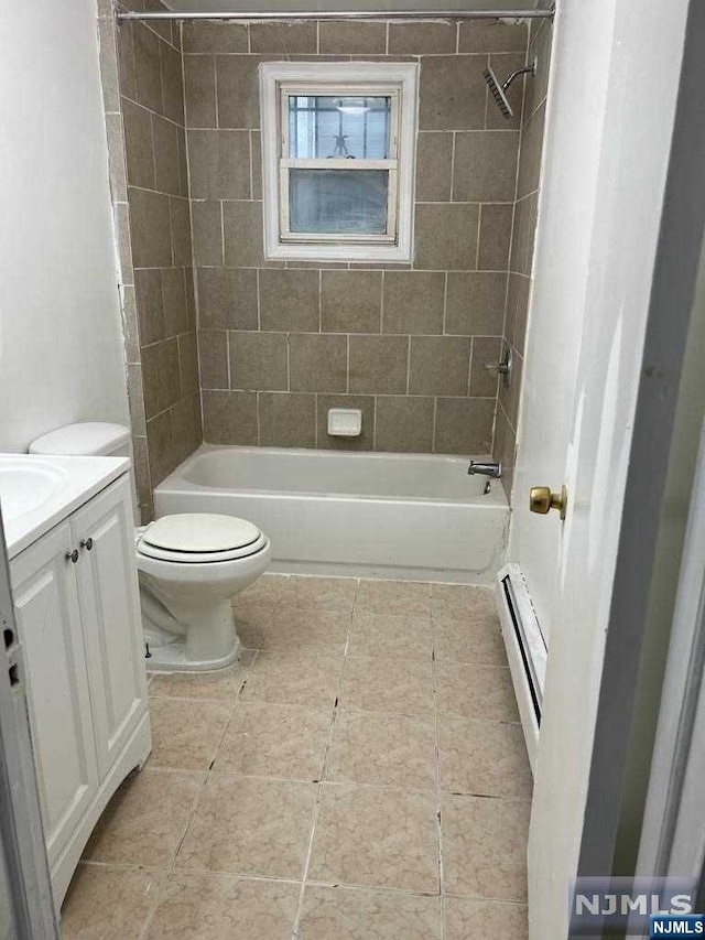 full bathroom featuring vanity, toilet, tiled shower / bath, and a baseboard heating unit