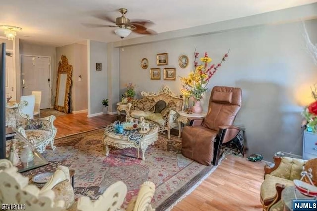 living room featuring hardwood / wood-style floors and ceiling fan