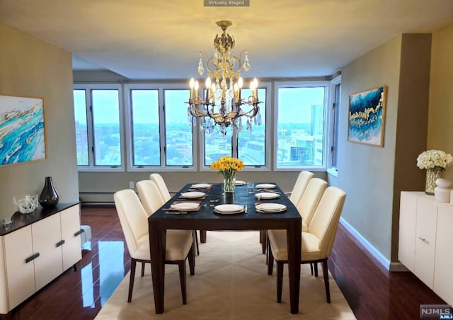 dining space featuring dark wood-type flooring, a baseboard radiator, and an inviting chandelier