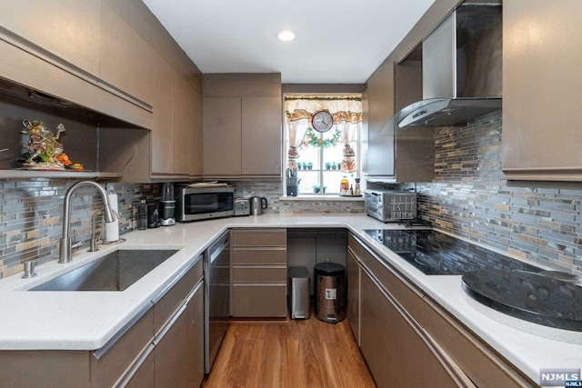 kitchen with appliances with stainless steel finishes, backsplash, sink, wall chimney range hood, and gray cabinets