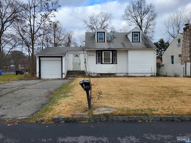 cape cod home featuring a garage and a front lawn