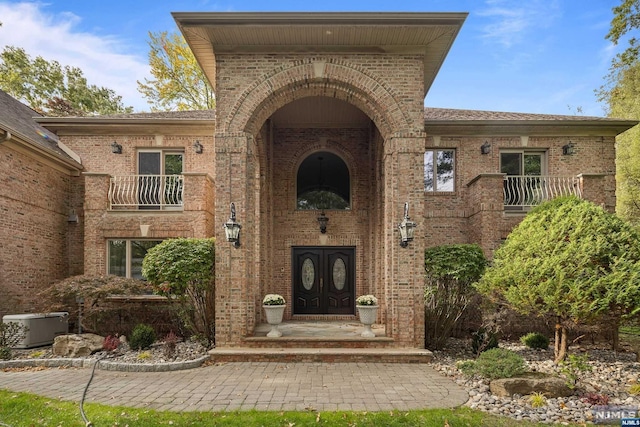 entrance to property with a balcony and cooling unit